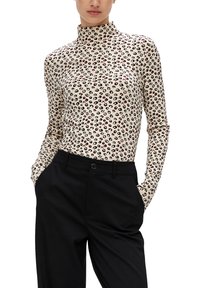 Długi rękaw, top z wysokim kołnierzem, wykonany z elastycznej tkaniny, z kremowym tłem i czarno-czerwonym wzorem w panterkę. W połączeniu z czarnymi spodniami.