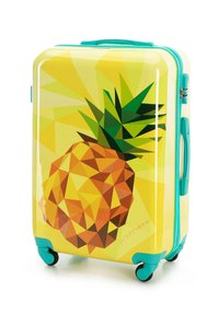 Maleta rígida amarilla con asas y ruedas azul verdoso, que presenta un gran diseño geométrico de piña en la parte delantera.