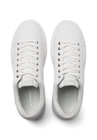 Par de zapatillas blancas con cordones y ojales plateados, vistas desde arriba, con el texto "KARL LAGERFELD" en la plantilla y la lengüeta.