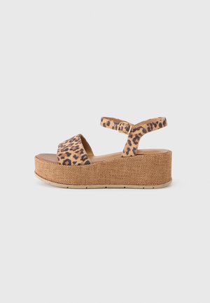 Leopard print platform sandal with a textured brown cork base, open toe design, and an adjustable ankle strap with a gold buckle.