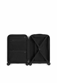 Zwarte koffer met een gladde buitenkant. Interieur beschikt over een gaas ritsvak en verstelbare banden in een patroonvoering. Vier wielen voor mobiliteit.