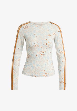 Chemise ajustée à manches longues avec motifs floraux bleu clair et marron et rayures orange courant le long des manches sur fond blanc.