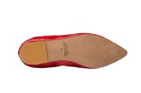 Zapato rojo de punta afilada con un acabado texturizado y brillante. Suela de goma beis con patrones de agarre. La información estampada incluye "Hecho en España" y talla 37.