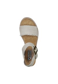 Sandal in beige chiaro con cinturini in tessuto, bordi sfrangiai, soletta in schiuma memory e fibbia metallica regolabile. Design con suola piatta per il comfort.