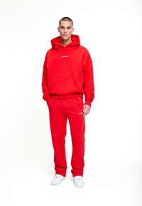 Pegador LOGO WIDE PANTS - Pantalones deportivos - washed red/white gum