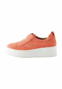 Korall színű slip-on sportcipő sima bőr felsőrésszel, fehér platform talppal és finom varrási részletekkel. Lapos sarok és lekerekített orrdesign.