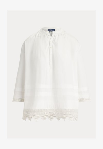 Άσπρο μπλούζα με μακριά μανίκια, γιακά με κουμπιά, σούρα στη λαιμόκοψη και διακοσμητική δαντέλα στα μανίκια και στο τελείωμα.