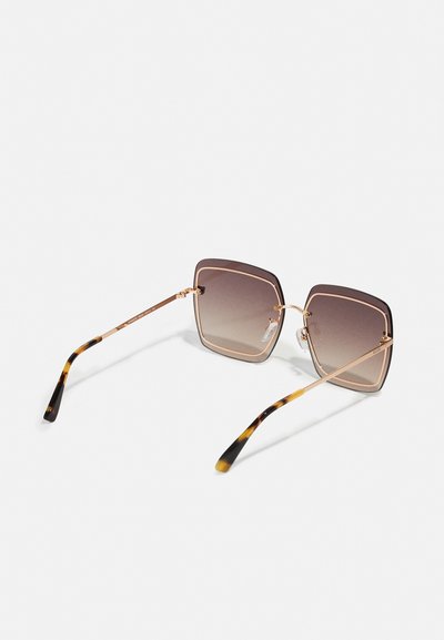 Lunettes de soleil carrées avec verres dégradés marron, monture en métal doré et branches à motif écaille de tortue. Plaquettes de nez transparentes pour plus de confort.