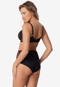 Czarny zestaw bielizny składający się z przezroczystego biustonosza z siateczki oraz majtek w wysokim talii z dekoracyjnymi akcentami z koronki, podkreślający gładkie dopasowanie i nowoczesny design.