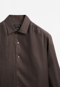 Braunes Leinenhemd mit glatter Textur, klassischem Kragen und durchgeknöpfter Vorderseite mit passenden Knöpfen, von Massimo Dutti.