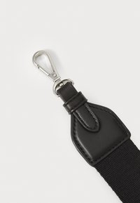 Sort vævet rem med en struktureret overflade, der har en sort læderforbinder og en sølvfarvet metalclips. Enkel og funktionel design.