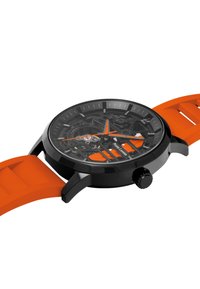 Sort urkasse med transparent urskive, orange accenter og en tekstureret orange silikonerem, med timemarkeringer og en optrækskrone.