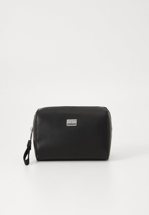 Zwarte synthetische leren tas met zilveren logo plaat, afgeronde rechthoekige vorm, ritssluiting en een polsband voor gemakkelijk dragen.