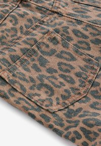 Tessuto con stampa leopardo a superficie texurizzata in marrone caldo e teal. Presenta una tasca visibile e dettagli di cucitura a contrasto.