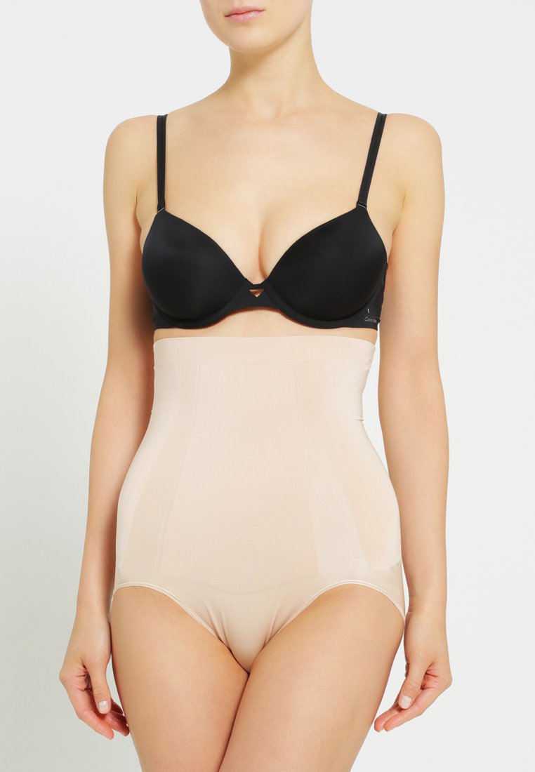 Lenjerie modelatoare cu talie înaltă, de culoare nud, fabricată dintr-un material neted, având un design fără cusături și o bandă lată la talie pentru suport și confort.