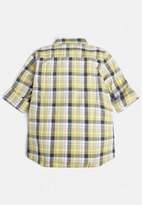 Chemise à manches courtes en tartan jaune, blanc et marine, avec un col boutonné et des manches roulées, un ourlet droit et un empiècement au dos.