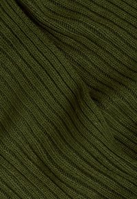 Primeiro plano de um tecido malha canelada verde escura com padrões texturizados verticais visíveis e dobras suaves.