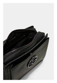 Borsa a tracolla in pelle nera textured con logo in metallo, scomparto principale aperto con zip e tasca interna con zip su uno sfondo neutro.