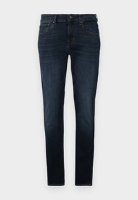 Tamno plave traperice od denima. Slim fit dizajn s pet džepova, diskretno šivanje i dugme za zatvaranje u struku. Glatka tekstura.