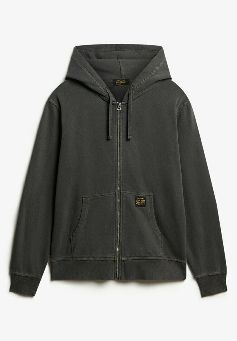 Szara bluza z kapturem zapinana na zamek wykonana z miękkiego materiału, z kieszonką z przodu, regulowanymi sznurkami oraz małą naszywką z logo w pobliżu kieszonki.