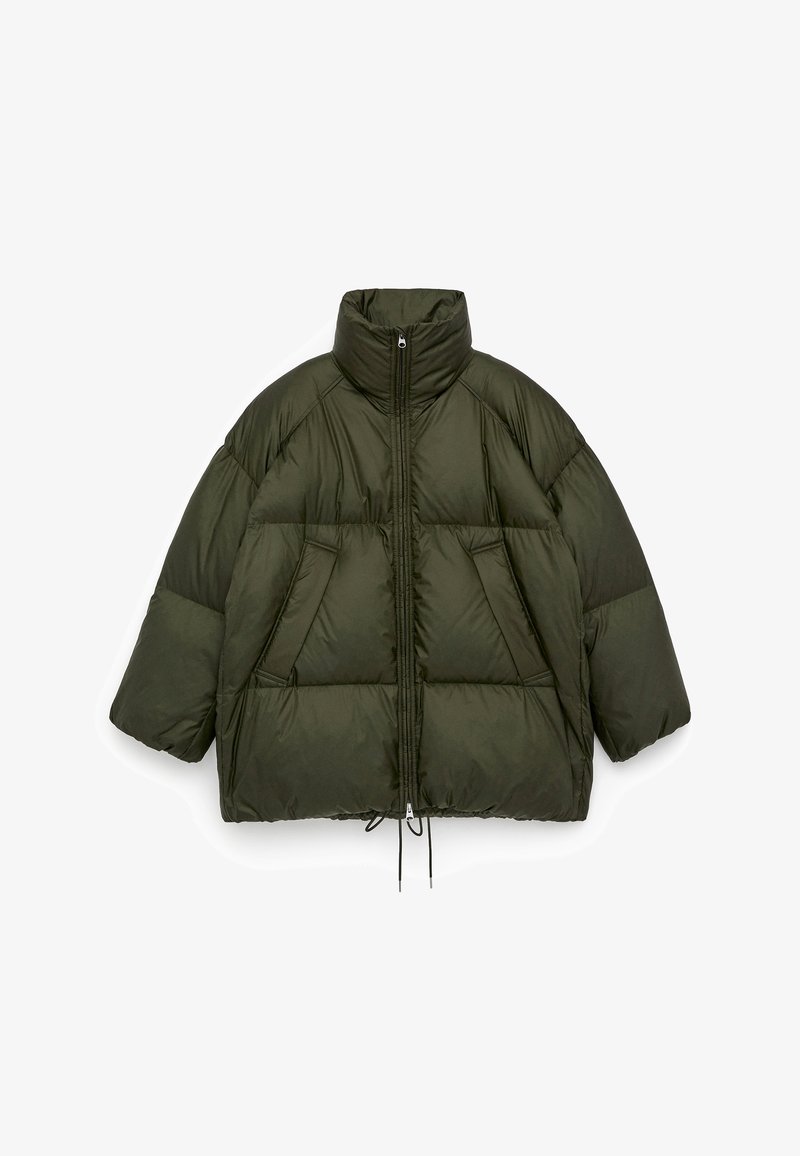 Olive green puffer jacket with high collar, zip front, oversized shape, two front pockets, and drawstring waist. Smooth, padded texture.