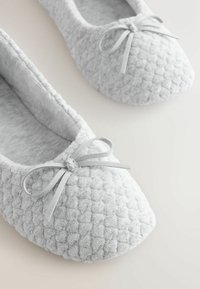 Papuci gri cu finisaj texturat, cu vârf rotunjit și un fundiță decorativă din material moale în partea din față.