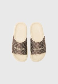 Brown patterned slide sandals with an ivory base, featuring a textured footbed and the text "AIR JORDAN" in gold on the strap.