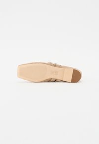Nøttsuede høye sandaler med teksturert såle, med tynne stropper og blokkheal. Glatt overflate med en svak glans.