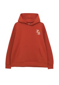 Sudadera de color óxido hecha de un tejido suave. Dispone de un bolsillo frontal, puños acanalados y un diseño bordado en el pecho.