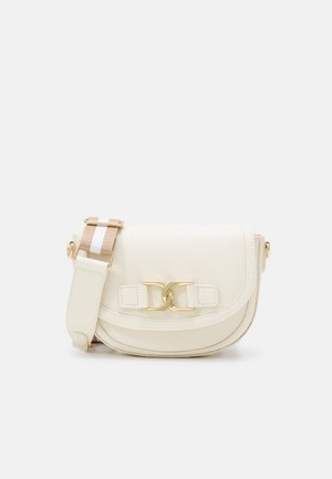 Sac bandoulière en cuir couleur crème avec fermoir doré et bandoulière ajustable beige et blanche sur fond uni.
