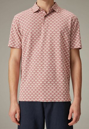 Short-sleeve polo shirt in light red with white half-shell pattern. Features a collared neck and buttons, made from a textured fabric.