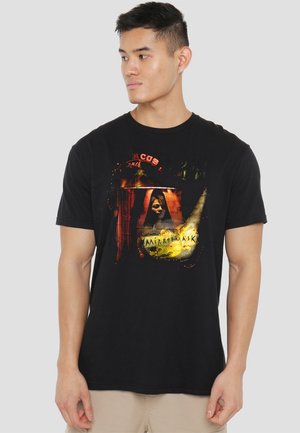 Black cotton t-shirt featuring a graphic print with a vintage design, incorporating shades of red, yellow, and a figure in a mask.