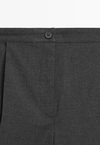 Pantaloni grigi con una texture liscia, caratterizzati da una chiusura con un singolo bottone e pince. La vita include passanti per cintura per un supporto aggiuntivo.