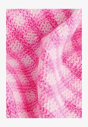 Stickad filt med en vågig struktur i nyanser av rosa och ljusrosa, med ett lager av zigzag-mönster, mjukt och lätt material.