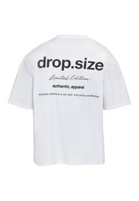 T-shirt blanc à manches courtes avec texte noir dans le dos indiquant « drop.size Limited Edition authentic, apparel » et une impression plus petite en bas.
