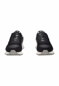 Scarpe da ginnastica nere in un mix di materiali mesh e camoscio, con allacciatura prominente e una suola grigia con una texture rigata.