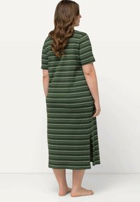 Abito maxi a righe in tonalità di verde con maniche corte, spacco laterale e vestibilità comoda. Realizzato in morbido tessuto elasticizzato.