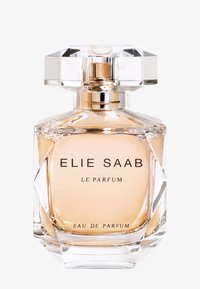 Transparent glass parfymeflaske med en oktagonal krystallhett. Inneholder lyse amberfarget væske. Har en fet svart tekstetikett og et geometrisk design.