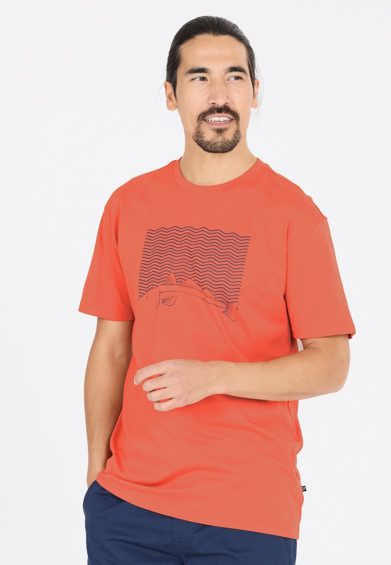 Orange bomull t-shirt med rund hals, med ett svart vågmönster och en fiskgrafik på framsidan. Kort ärm och avslappnad passform.