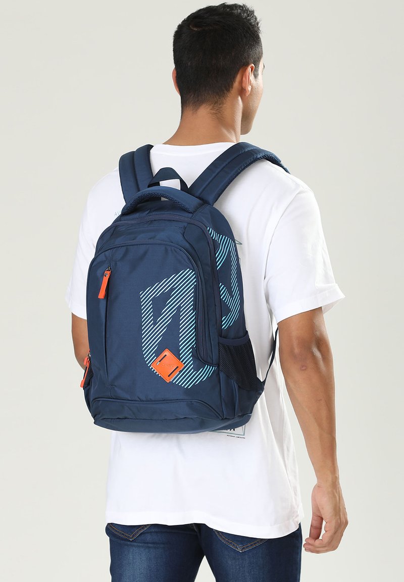 Zaino navy con un motivo geometrico blu e bianco, dettagli arancioni, numerosi scomparti, spallacci ergonomici e una texture in tessuto resistente.