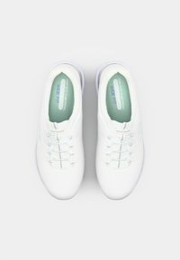 Sneakers bianchi con una tomaia in mesh testurizzato, dotati di una vestibilità ampia, lacci elastici e una soletta verde chiaro con il marchio "SKECHERS".