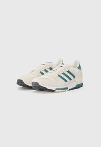 Witte sneaker met teal accenten, voorzien van een bovenwerk van suede en mesh, een ontwerp met drie gestreepte lijnen, vetersluiting en rubberen zool.