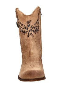 Tan suede cowboylaars met een lage hak, complexe stiksels en een uitgesneden detail in luipaardprint op de schacht. Zijrits voor gemakkelijke instap.