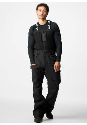 Schwarze Schnee-Overalls mit verstellbaren Trägern, einer mit Reißverschluss versehenen Brusttasche und mehreren Seitentaschen. Glatte Textur und lockere Passform.