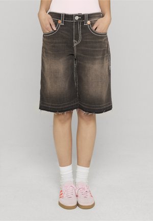 Bermudas de denim negro con dobladillo deshilachado, costuras en contraste, cinco bolsillos y dos detalles de botones de cobre en la cintura.