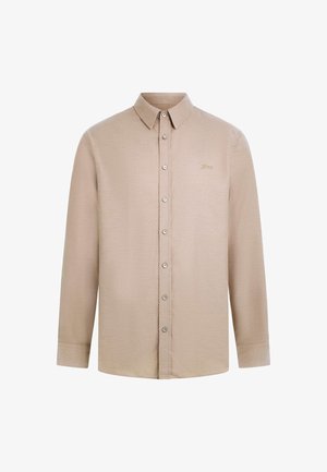 Beeži pika pikka varrukate nuppudega särgist, millel on klassikaline krae, üks rindkere tasku ja peen logo tikand.