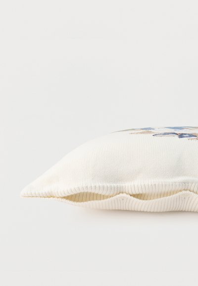 Λευκό πλεκτό ορθογώνιο μαξιλάρι με μπλε και μπεζ διακοσμητικό μοτίβο σταυρού σε απλό φόντο.