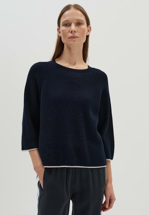 Navy knitted sweater with three-quarter sleeves, ribbed texture, and a crew neckline. Hem features a contrasting white trim detail.