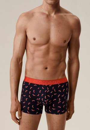 Męskie bokserki w kolorze granatowym z czerwonym ściągaczem. Ozdobione wzorem małych czerwonych skarpetek. Miękki, elastyczny materiał zapewniający komfort i dopasowanie.