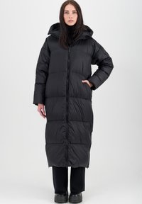 Long manteau d'hiver noir avec fermeture éclair à l'avant, capuche et deux poches latérales. Le design présente un motif matelassé pour l'isolation et la chaleur.